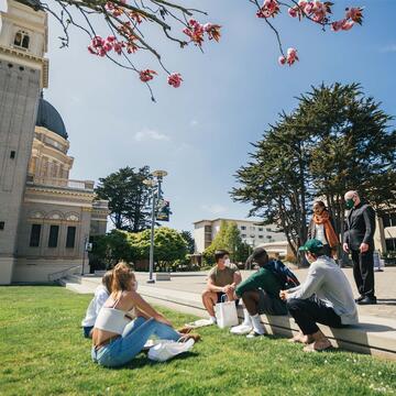 Students on the grass speak to USF President.