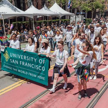 Students and staff carry a USF banner in the SF Pride Parade.