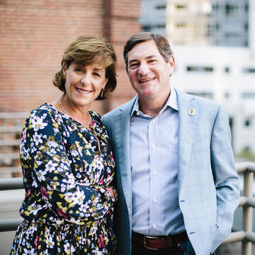 Two people pose together out doors