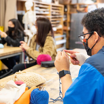 Student works on knitting project in art class.