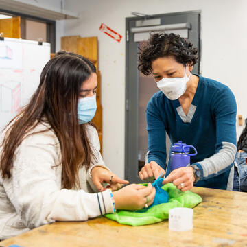 Professor helps a student with an art project.