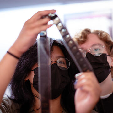 Students examine a strip of film.