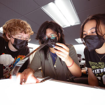 Students examine film at a light table.
