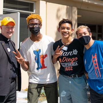 Students pose with USF President Fr. Fitzgerald on campus.
