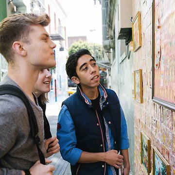 Student looking at murals in San Francisco