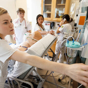 Nurse handles equipment in hospital room