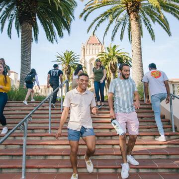 A number of students pass each other on the stairs leading to Lone Mountain.