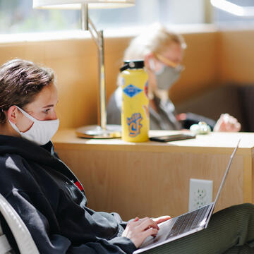 Students study on their laptops on the couches in the lounge in UC.