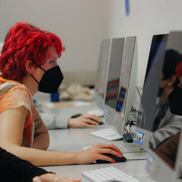 Student looks at a large computer monitor while in a design lab classroom.