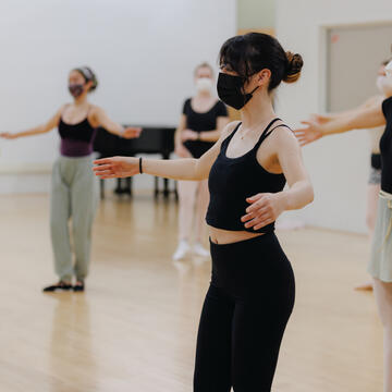 Students in a dance class work on a spin.