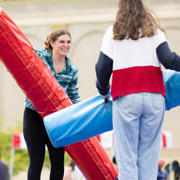 Students battle with large stuffed tubes at CAB carnival.