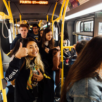 Student gives a thumbs up while riding the bus