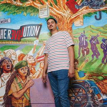 USF student in front of a mural