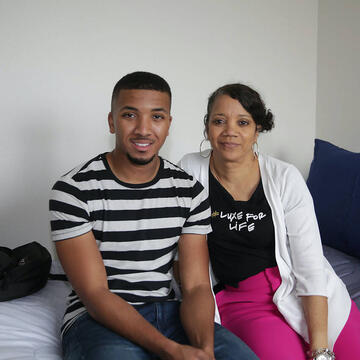 Student and parent sit together in dorm