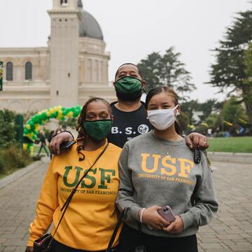 Student and parents stand outside and pose for a picture