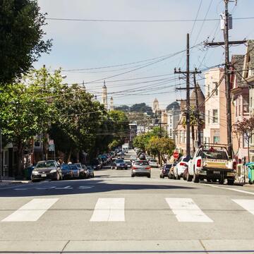 Crosswalk with cars parked on the side of a street