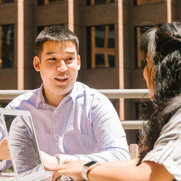 Two students talking on the Downtown Campus roof deck