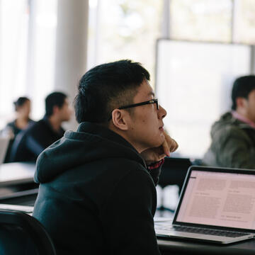 student in class with laptop