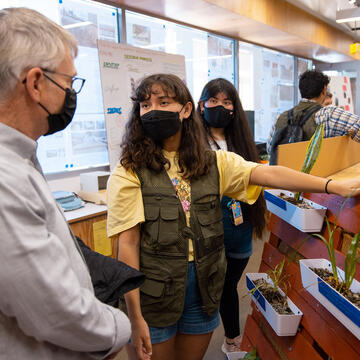 Students describe exhibit to professor