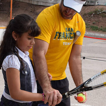 Charlie Cutler and kid holding a tennis raquet