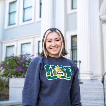 a student in a USF shirt smiles at the camera