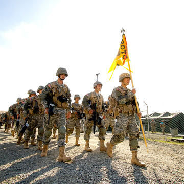 ROTC holding a flag and marching