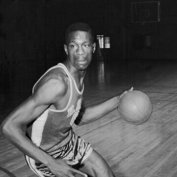 Bill Russell dribbles on a court