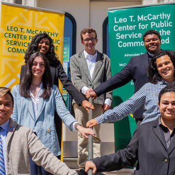 Students pose on a staircase in front of banners for the Leo T. McCarthy Center