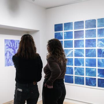 Two people standing in front of the Elemental Exposures exhibit