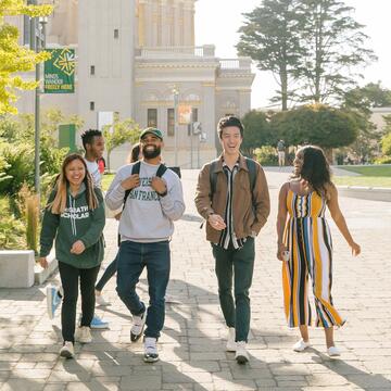 Students walk across campus on a sunny day