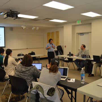 visiting scholar holding microphone in a room