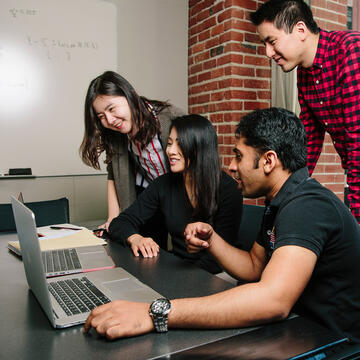 students in class overlooking laptops