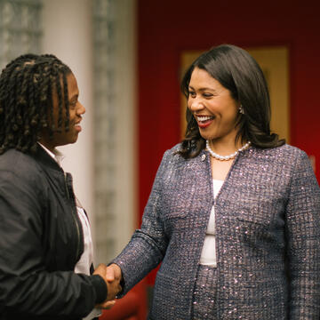 London Breed shaking hands with a citizen