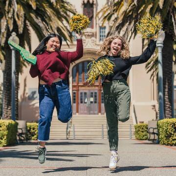 Two students jumping in the air