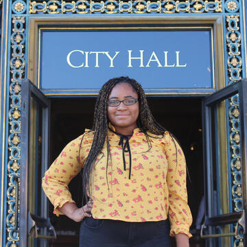 Student stands in front of an elaborate door at SF City Hall