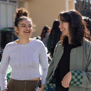 Two students walking and talking on campus