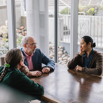 Engineering professors conversing in a meeting room