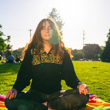 student meditating outside