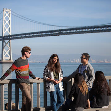 Five people in front of the Bay Bridge