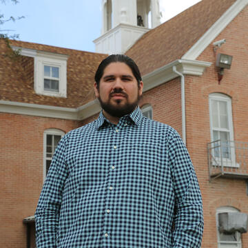 Maka Black Elk stands in front of a church.