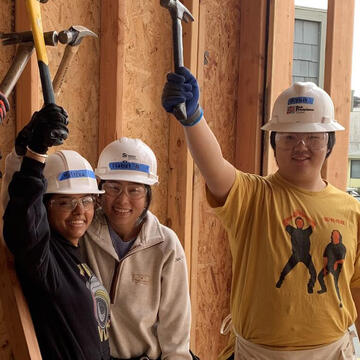 Ryan Futagaki and classmates holding up hammers