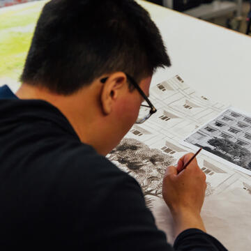student drawing a building from a photograph