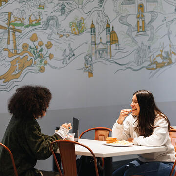 Two USF students eating in Koret Lodge