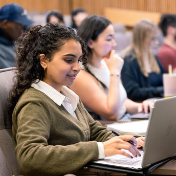 Student in class types on a laptop