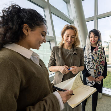 student flipping through book as teacher looks on