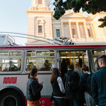 USF students boarding Muni in front of St. Ignatius Cathedral