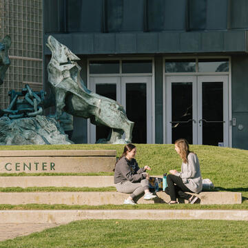 Two USF students chatting in front of Gleeson Library