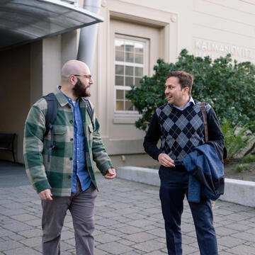 Two USF students walking and chatting on campus