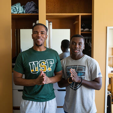 two students standing together in a dorm