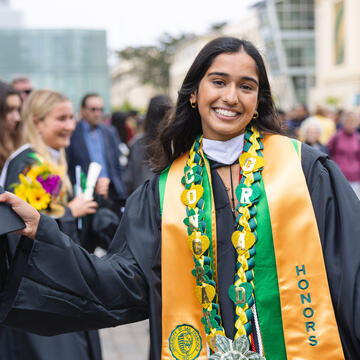 New graduate poses in regalia.
